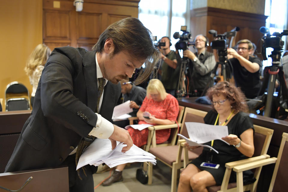 A man hands out copies of the court verdict on American rapper A$AP Rocky at Stockholm District Court, in Stockholm, Sweden, Wednesday Aug. 14, 2019. Swedish court on Wednesday found American rapper A$AP Rocky guilty of assault for his role in a June 30 street brawl in Stockholm. (Anders Wiklund / TT via AP)