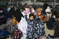 Two girls from Afghanistan wait with other evacuees to fly to the United States or another safe location in a makeshift gate inside a hanger at the U.S. Air Base in Ramstein, Germany, Wednesday, Sept. 1, 2021. The United States is using the military base in Ramstein, Palatinate, as a hub for the evacuation of shelter seekers and local forces from Afghanistan. (AP Photo/Markus Schreiber)