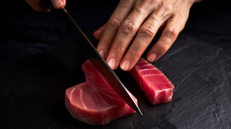 Person cutting tuna steaks