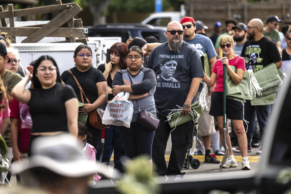 In an orderly queue, residents patiently wait with their shovels and sand bags at Wildwood Park in Saturday, Aug. 19, 2023, San Bernardino, Ca. (Watchara Phomicinda/The Orange County Register via AP)