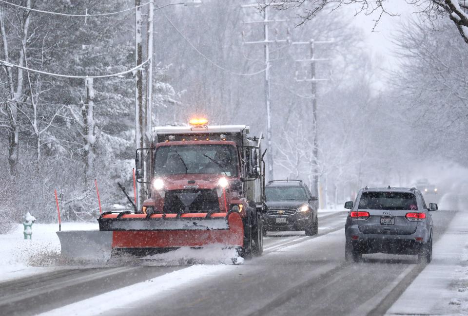 Road conditions are slippery Tuesday as a snowplow clears a path for early morning traffic in Appleton.