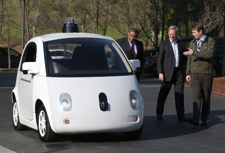 Google's Chris Urmson (R) shows a Google self-driving car to US Transportation Secretary Anthony Foxx (L) and Google Chairman Eric Schmidt (C) at the Google headquarters on February 2, 2015 in Mountain View, California