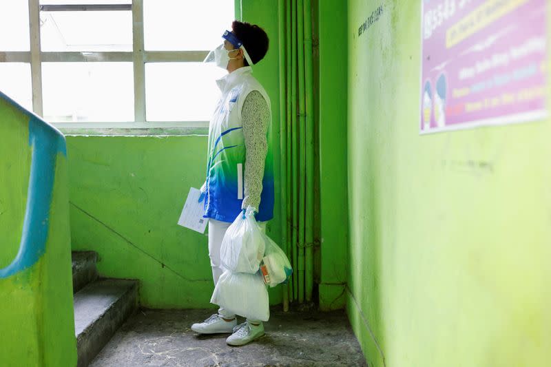 A volunteer holds anti-epidemic bags as she delivers them to residents in Hong Kong