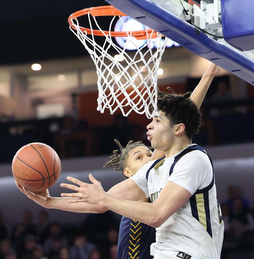 Archbishop Williams' Josh Campbell scores a basket on St. Mary's Omni Merryman during their MIAA Division 3 title game at the Tsongas Center in Lowell on Saturday, March 18, 2023.