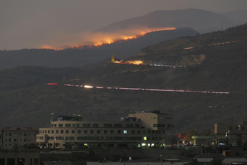 FILE - In this Saturday, Oct. 31, 2020 file photo, forest burns in the mountains after shelling by Azerbaijan's artillery during a military conflict outside Stepanakert, the separatist region of Nagorno-Karabakh. Armenia accused neighboring Azerbaijan of systematically promoting ethnic hatred against Armenia citizens, as the two nations that fought a six-week war last year faced off at a United Nations court on Thursday Oct. 14, 2021. (AP Photo/File)