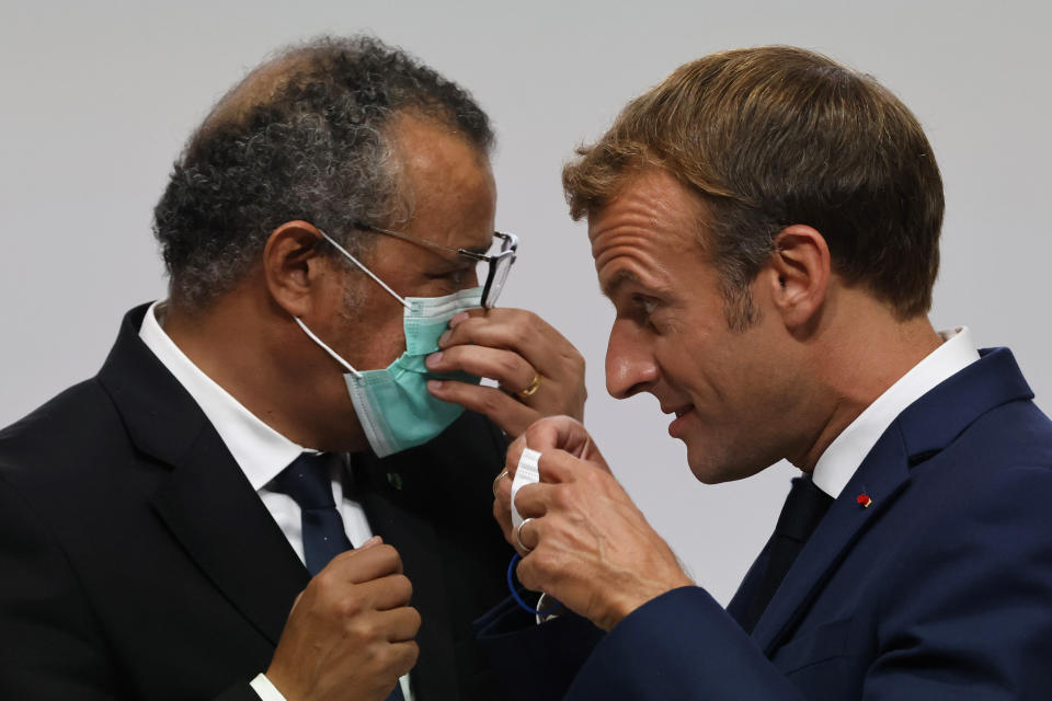 French President Emmanuel Macron, right, speaks with WHO Director-General Tedros Adhanom Ghebreyesus during the opening of the World Health Organisation Academy in Lyon, central France, Monday, Sept. 27, 2021. (Ludovic Marin, Pool Photo via AP)