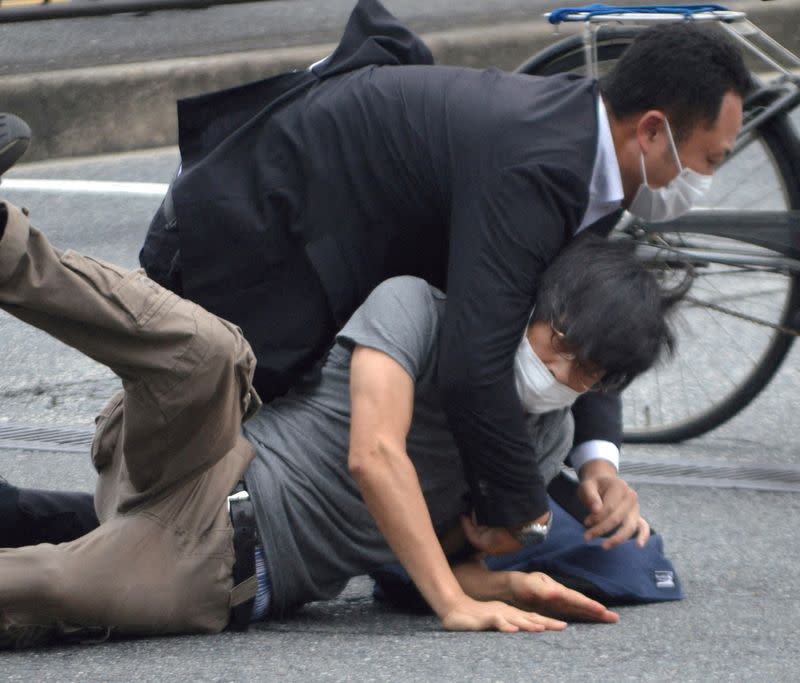 FILE PHOTO: A man, believed to be a suspect shooting former Japanese Prime Minister Shinzo Abe is held by police officers at Yamato Saidaiji Station in Nara