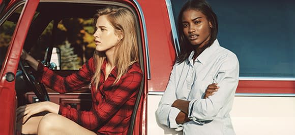 A pair of Abercrombie models pose inside and beside a pickup truck.