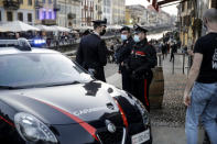 Carabinieri, Italian police officers, patrol the Naviglio Grande canal, in Milan, Italy, Saturday, Feb. 27, 2021. Police vans blocked entrance to Milan's trendy Navigli neighborhood Saturday evening after the mayor announced increased patrols to prevent gatherings during a spring-like weekend. The Lombardy region where Milan is located is heading toward a partial lockdown on Monday, and Mayor Giuseppe Sala said in a video message that he was disturbed by scenes of people gathering in public places, often with their masks down. (AP Photo/Luca Bruno)