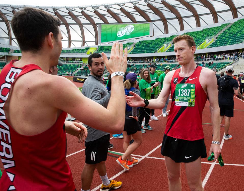 The 2022 Eugene Marathon winner Tyler Morse of Beaverton, right, is congratulated by second place finisher Johnny Rutford, left, on the track at Hayward Field Sunday.