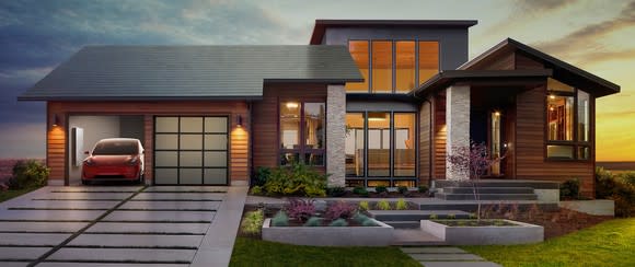 A Tesla Model 3 parked in the garage of a house with a Powerwall and Tesla solar roof