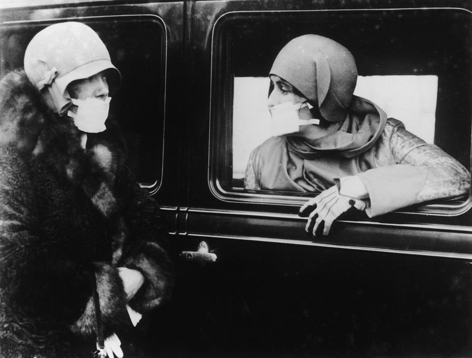 Two women wearing flu masks during the flu epidemic which followed the First World War. (Photo by Keystone/Getty Images)