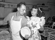 FILE - In this April 22, 1944 file photo, Jane Powell, who just completed work in "Song of the Open Road" does her bit at the canteen drying dishes for dishwasher Buster Keaton, in Los Angeles. Jane Powell, the bright-eyed, operatic-voiced star of Hollywood's golden age musicals who sang with Howard Keel in “Seven Brides for Seven Brothers” and danced with Fred Astaire in “Royal Wedding,” has died. Thursday, Sept. 16, 2021. She was 92. (AP Photo/File)