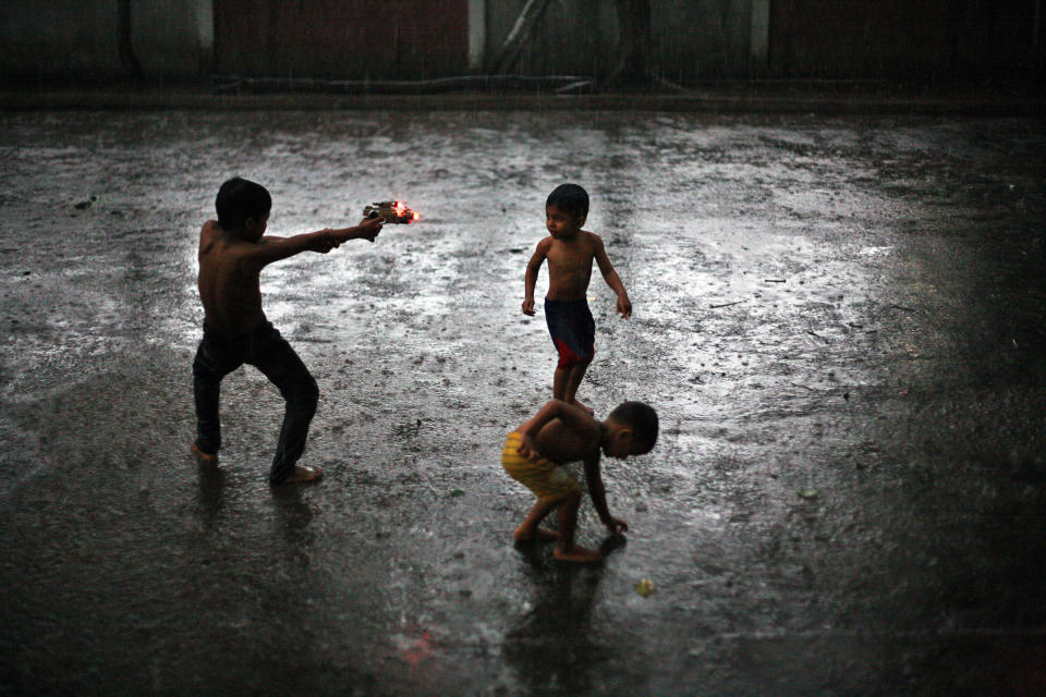 In this Aug. 7, 2013 photo, Rohingya refugee children play in the rain outside their temporary shelter in Medan, Indonesia. Indonesia has been sympathetic to the Rohingya, who have been fleeing violence in Myanmar in greater numbers, and the Indonesian president has sent a letter to his Myanmar counterpart calling for an end to the crisis. But Indonesia has not opened its doors to the Rohingya. It only allows them to stay until they can be resettled elsewhere, which can take years. (AP Photo/Binsar Bakkara)