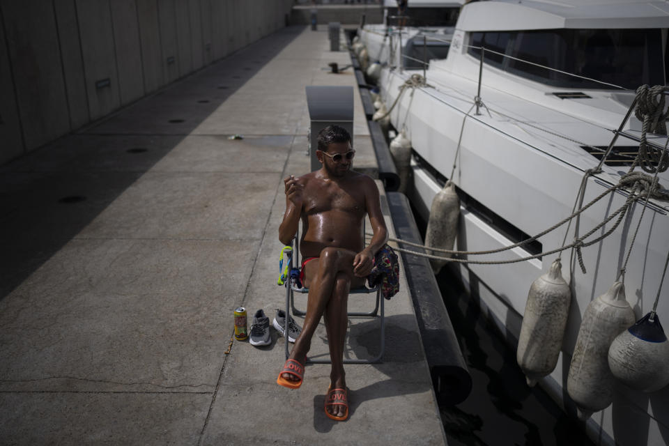 A man sunbathes during a heat wave in Marseille, southern France, Wednesday, June 15, 2022. (AP Photo/Daniel Cole)