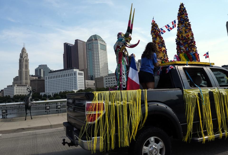 Deogo Gutierrez adjusts his "Olympic Devil" headpiece, a representation of the Dominican Republic celebration of Carnival, on Saturday during the first Columbus Latine/Hispanic Heritage Month parade.