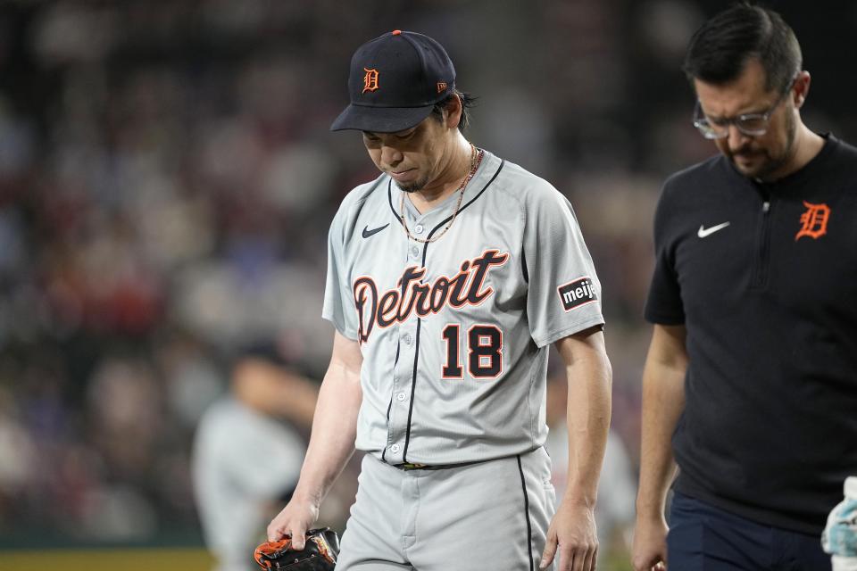 Detroit Tigers' Kenta Maeda walks off the field with a member of the team staff during the first inning of the team's baseball game against the Texas Rangers, Wednesday, June 5, 2024, in Arlington, Texas. (AP Photo/Tony Gutierrez)