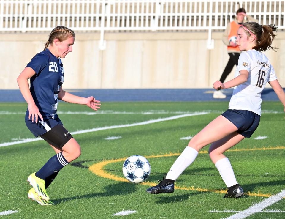 Petoskey's Madylin Smith (left) meets a Cadillac player at the ball during the first half Tuesday. Smith, a freshman, scored her first career varsity goal in the game.