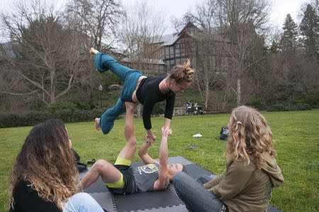 Sean Gerhardt, 25, and Emily Otte, 28, practice acro-yoga together as Suellen Lima, 30, left, and Naomi Binzen, 26, right, watch while in Lithia Park in Ashland, Oregon February 4, 2015. REUTERS/Amanda Loman