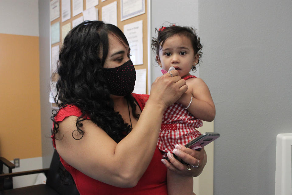 This May 17, 2021 image shows Margarita Mora preparing to drop off her daughter at Cuidando Los Ninos in Albuquerque, N.M. The charity provides housing, child care and financial counseling for mothers, all of whom will benefit from expanded Child Tax Credit payments that will start flowing in July to roughly 39 million households. (AP Photo/Susan Montoya Bryan)