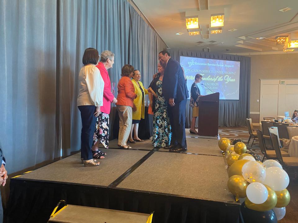 Kaffie Middle School teacher Jane Lee-Rhodes (center) hugs Corpus Christi ISD Superintendent Roland Hernandez after being named Regional Middle School Teacher of the Year during the Education Service Center's Teacher of the Year Celebration on Friday, June 21, 2024 -Region 2.