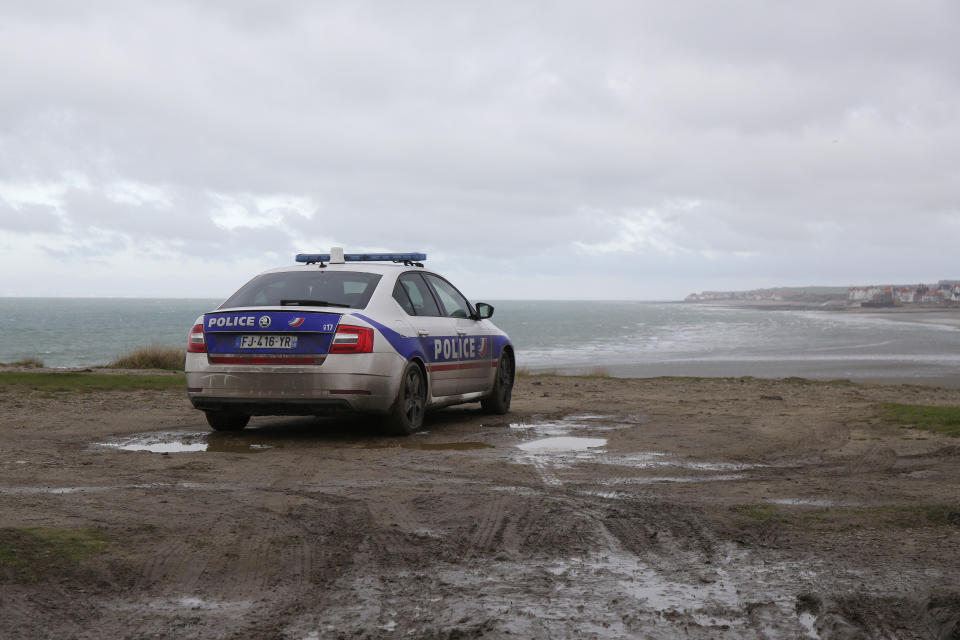 A police car parks over the shore in Wimereux, northern France, Thursday, Nov. 25, 2021 in Calais, northern France. Children and pregnant women were among at least 27 migrants who died when their small boat sank in an attempted crossing of the English Channel, a French government official said Thursday. French Interior Minister Gerald Darmanin also announced the arrest of a fifth suspected smuggler thought to have been involved in what was the deadliest migration tragedy to date on the dangerous sea lane.(AP Photo/Michel Spingler)