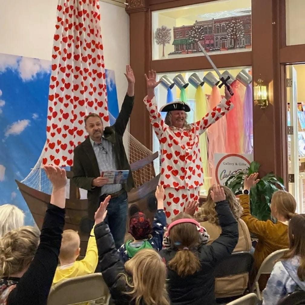 Author Rich Gritter (left) and Art Tolsma engage the crowd during a recent reading of "The Pirate's Pajamas" outside Carolyn Stich Studio.