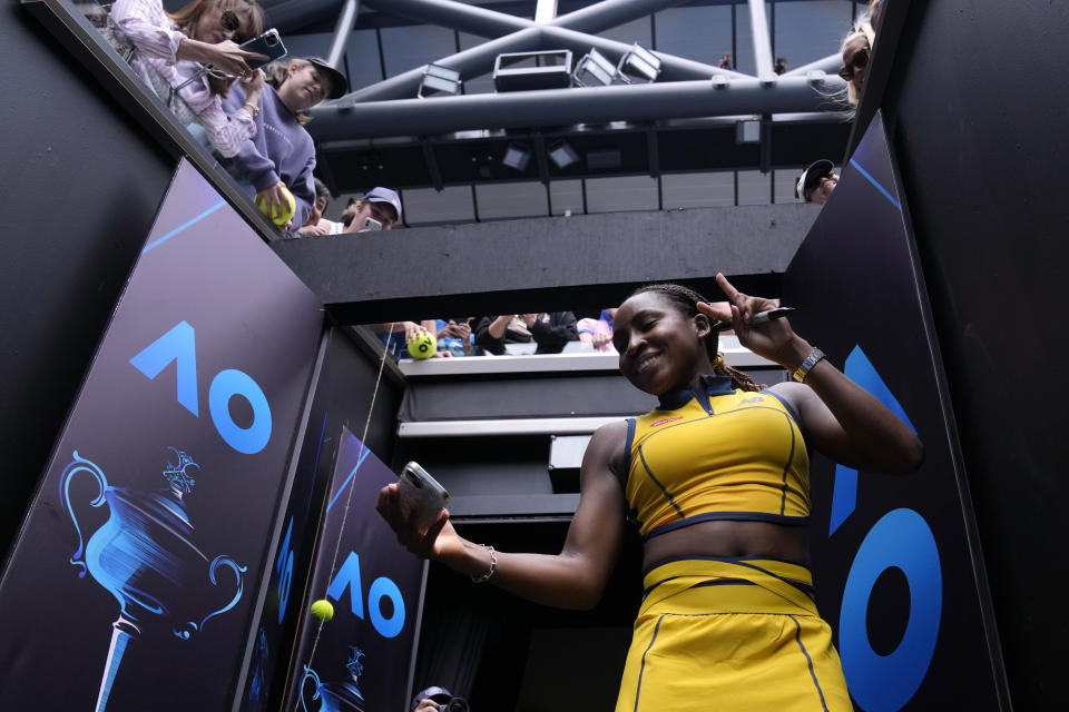 Coco Gauff of the U.S. takes a selfie for a fan following her third round win over compatriot Alycia Parks at the Australian Open tennis championships at Melbourne Park, Melbourne, Australia, Friday, Jan. 19, 2024. (AP Photo/Andy Wong)