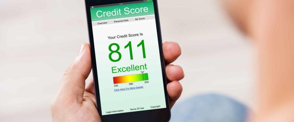 Man Holding Smart Phone Showing Credit Score Application On A Screen