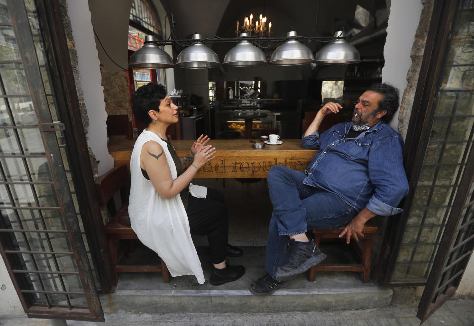 Walid Ataya, right, the owner of a bakery, restaurant, pizzeria, wine room and flower shop that occupy a strategic intersection leading into an upscale neighborhood in Beirut, Lebanon, speaks with one of his employees at his Bread Republic shop on June 18, 2020. Ataya had to close his restaurant, pizzeria and wine room for nearly three months during Lebanon's strict and early lockdown imposed in March. “We are in the stage of surviving day to day now,” Ataya said. “You cannot sit and do nothing. You have to take your chances.” (AP Photo/Hussein Malla)