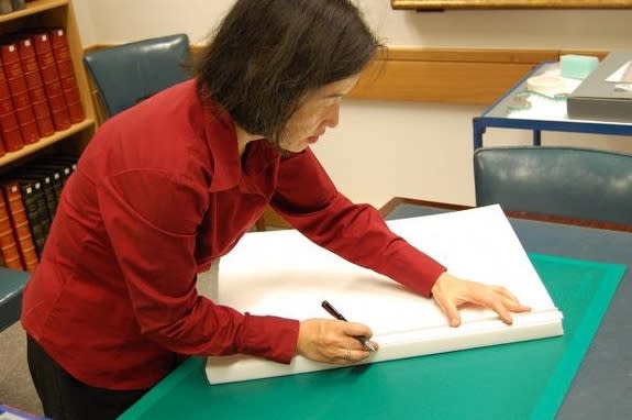 Conservator Kumiko Matsuoka of the British Library prepares temporary housing for the Burnt Magna Carta.