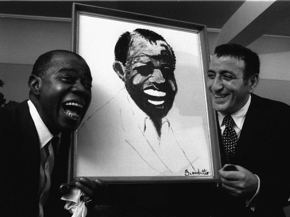 Tony Bennett presents Louis Armstrong a painting in 1970.