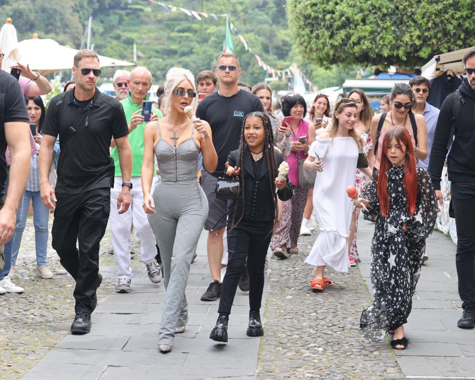 Kim Kardashian in a grey outfit with North West and Penelope Disick eating ice cream