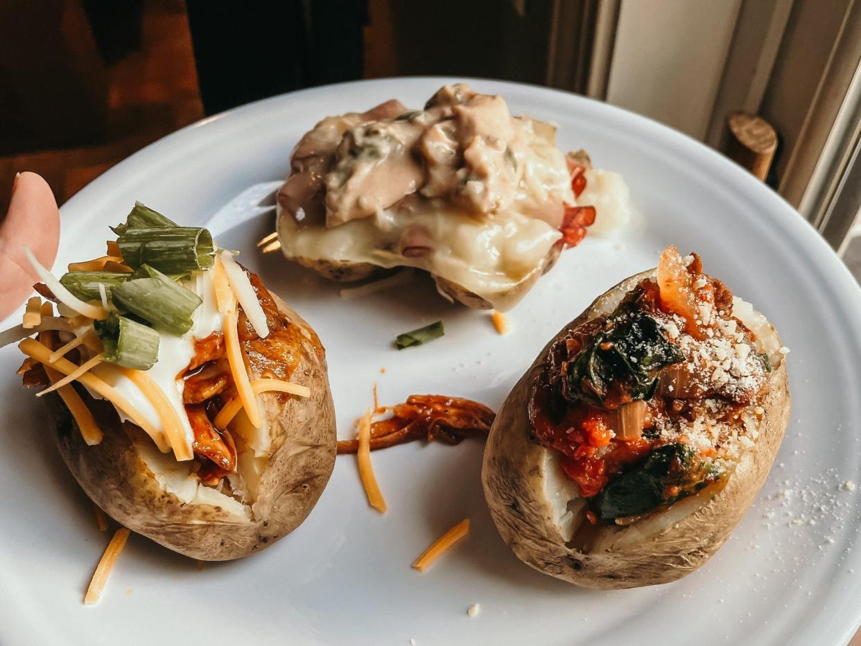 three loaded baked potatoes on a plate