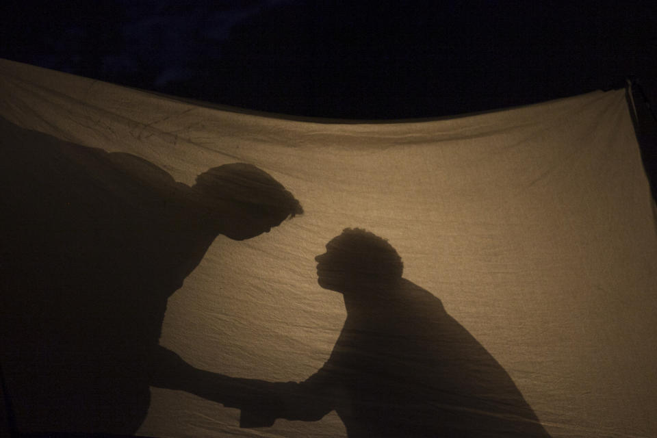 In this photo taken on Friday, Jan. 24, 2014 American tenor Tom Randle (Jack Twist), right, and Canadian bass-baritone Daniel Okulitch (Ennis del Mar), left, cast shadows on a tent during the press rehearsal of the production "Brokeback Mountain" at the Teatro Real, in Madrid, Spain. It was a short story, then a Hollywood movie. Now the tragic tale of cowboys in love is being reinvented again: Brokeback Mountain _ the opera. Ahead of its world premiere in Madrid, author Annie Proulx told The Associated Press that the form of opera presented an opportunity to explore the complexities of the tale in a way neither her own short story nor the movie by director Ang Lee were able to do. (AP Photo/Gabriel Pecot)