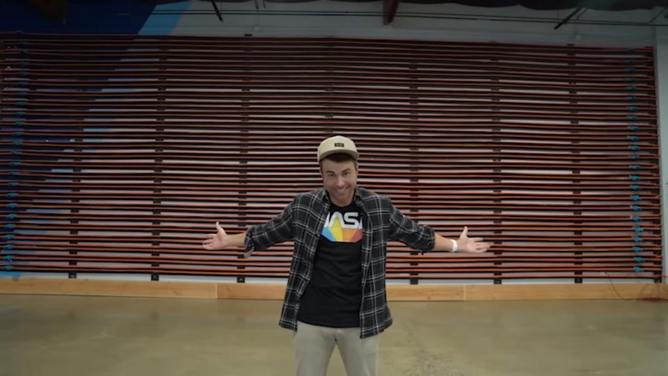 Mark Rober stands in front of Hot Wheels track switchbacks