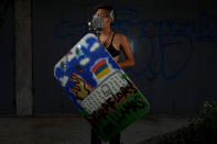 <p>A demonstrator holding a rudimentary shield that reads “Miraflores on fire,” poses for a picture before a rally against Venezuelan President Nicolas Maduro’s government in Caracas, Venezuela, May 24, 2017. She said: “I’m protesting because Venezuela is beautiful and it’s sad that everyone has to go. I fight because I don’t want to leave Venezuela, I want to grow here.” (Photo: Carlos Garcia Rawlins/Reuters) </p>