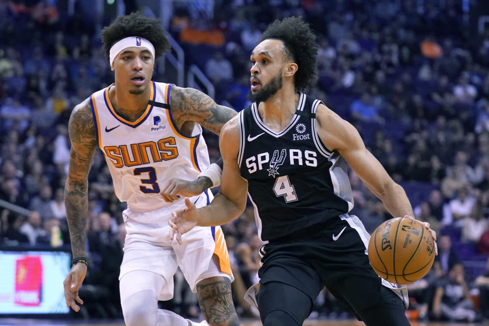 San Antonio Spurs guard Derrick White (4) drives past Phoenix Suns forward Kelly Oubre Jr. during the first half of an NBA basketball game Monday, Jan. 20, 2020, in Phoenix. (AP Photo/Rick Scuteri)