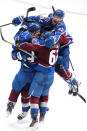 Colorado Avalanche defenseman Josh Manson (42) is congratulated by Samuel Girard (49), Artturi Lehkonen (62) and Gabriel Landeskog (92) after scoring in overtime against the St. Louis Blues in Game 1 of an NHL hockey Stanley Cup second-round playoff series Tuesday, May 17, 2022, in Denver. The Avalanche won 3-2. (AP Photo/Jack Dempsey)