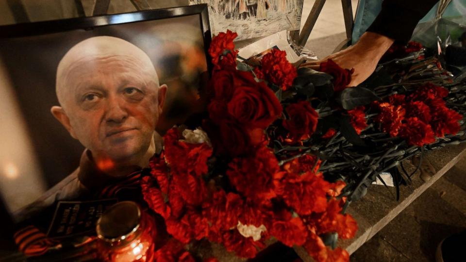 PHOTO: A man lays flowers at the makeshift memorial in honor of Yevgeny Prigozhin and Dmitry Utkin, a shadowy figure who managed Wagner's operations and allegedly served in Russian military intelligence, in Moscow, on August 24, 2023. (Natalia Kolesnikova/AFP via Getty Images)