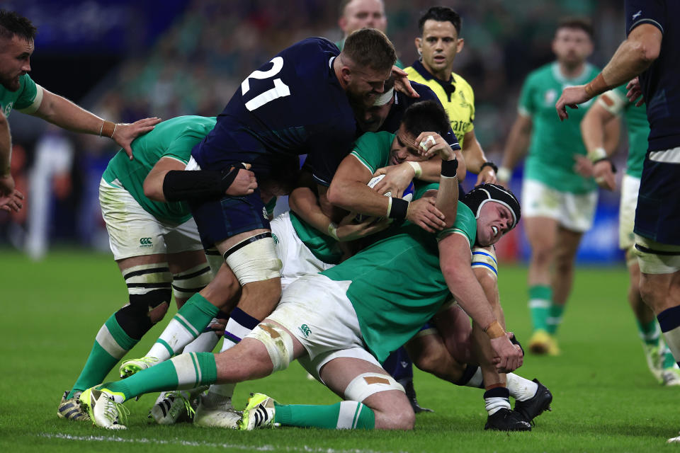 Scotland's Luke Crosbie, left, tries to get the ball from Ireland's Conor Murray, center, during the Rugby World Cup Pool B match between Ireland and Scotland at the Stade de France in Saint-Denis outside of Paris, Saturday, Oct. 7, 2023. (AP Photo/Aurelien Morissard)