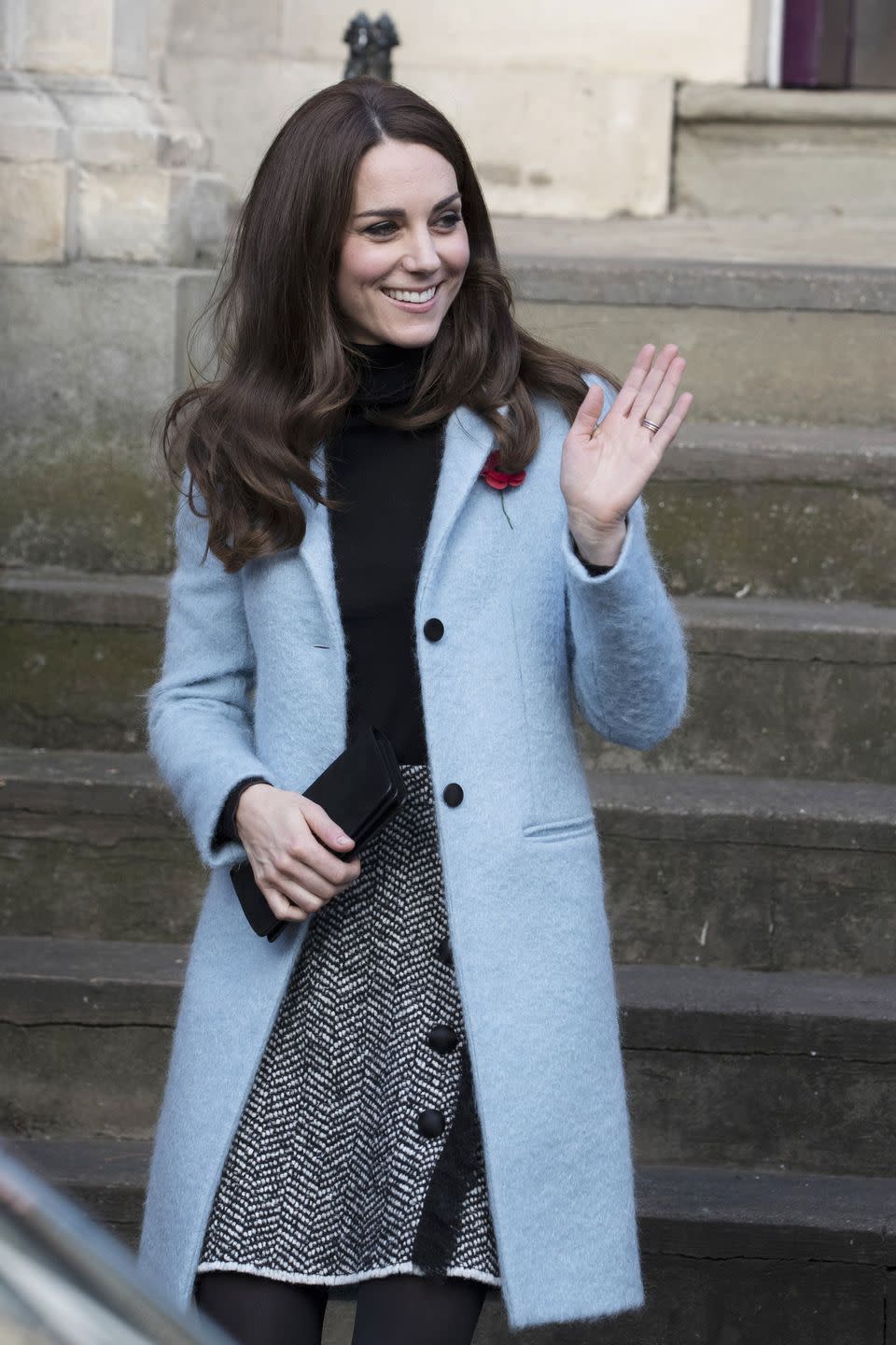 <p>In a light blue Mulberry coat, a black turtleneck, grey tweed Dolce & Gabbana skirt with button and fringe accents, a black leather clutch and black tights while visiting the Nelson Trust Women's Centre in Gloucestershire.</p>