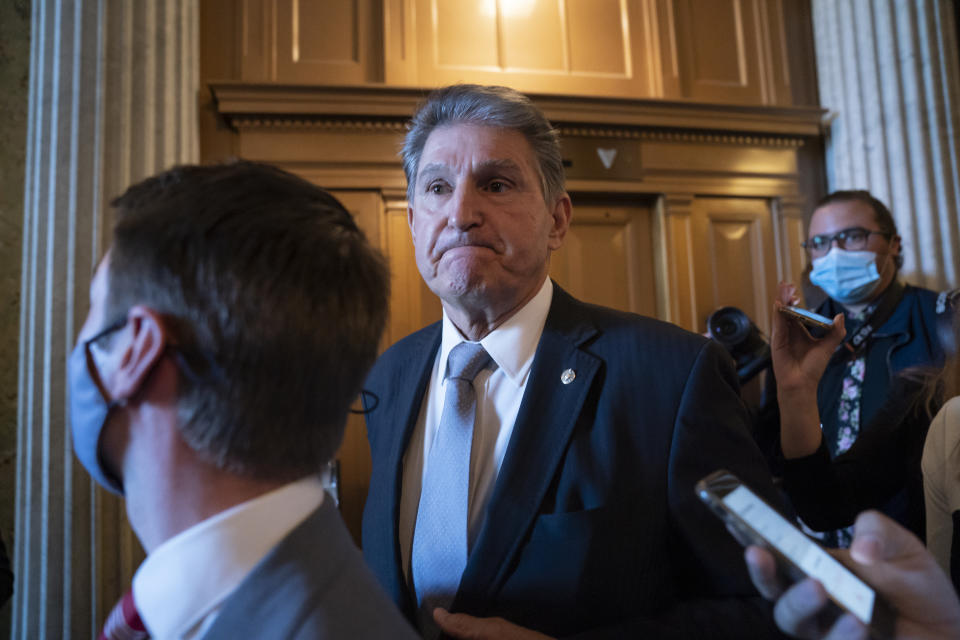FILE - Sen. Joe Manchin, D-WVa. is surrounded by reporters as he leaves the chamber after a vote, at the Capitol in Washington. The House passed a roughly $2 trillion social policy and climate bill Friday, Nov. 19, including $555 billion for cleaner energy, although the legislation is almost certain to be changed by the Senate. Cost-cutting demands by Manchin from the coal state of West Virginia, and that chamber’s strict rules seem certain to force significant changes to the bill. (AP Photo/J. Scott Applewhite, File)
