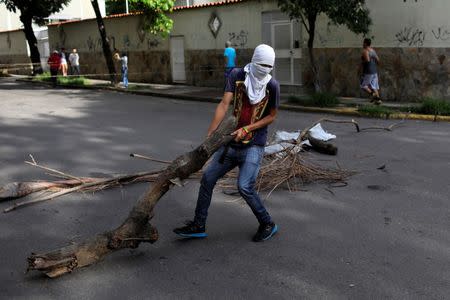 A demonstrator prepares a barricade during a strike called to protest against Venezuelan President Nicolas Maduro's government in Caracas, Venezuela, July 26, 2017. REUTERS/Marco Bello