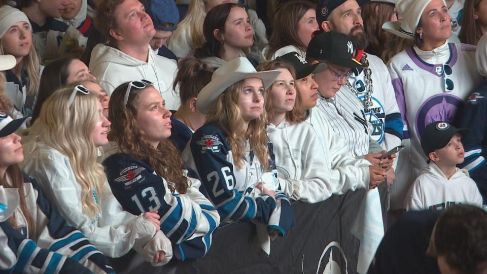 Jets fans stare blankly at one of the big screens set out for the street party on Tuesday night.