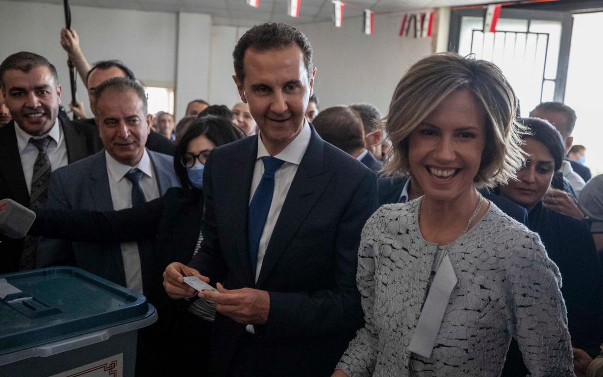 Syrian President Bashar Assad and his wife Asma vote at a polling station in eastern Ghouta on Wednesday - AP