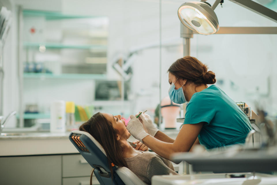 A woman sits for a dentist examination