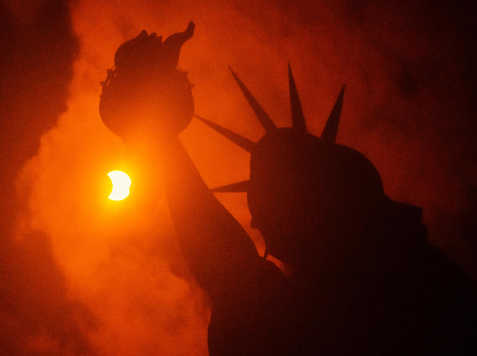 A partial solar eclipse is seen behind the Statue of Liberty at Liberty Island on Aug. 21, 2017 in New York City. While New York was not in the path of totality for the solar eclipse, around 72% of the sun was covered by the moon during the peak time of the partial eclipse. / Credit: Noam Galai/WireImage