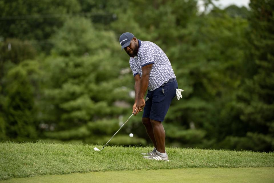 APGA golfer Daniel Augustus chips onto the green.