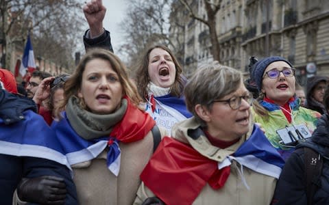 A Foulards rouges or red scarf protestor chants during the March for Republican Liberties, an anti-Gilets Jaunes (anti-yellow vest) movement - Credit: Kiran Ridley/Getty Images Europe